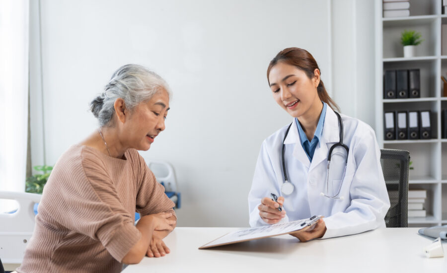 Doctor reviewing a 75 year old health assessment with an elderly patient in a Medicare-funded consultation in Australia
