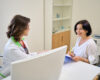 Woman discussing perimenopause symptoms with her doctor during a consultation, taking notes on when to seek medical advice
